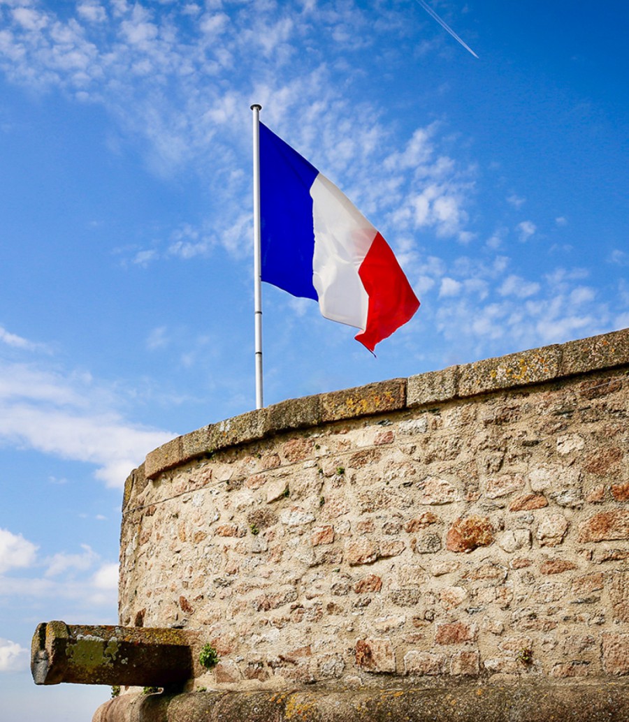 French flag at Mont Saint Michel lookout ScaleWidthWzE1MDBd